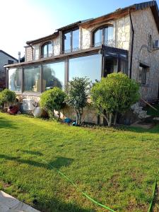 a house with windows and a lawn in front of it at Villa Atroa Gölevi in Orhangazi