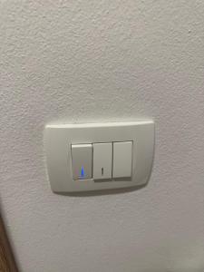 un interruttore della luce su una parete con una luce blu di Apartma Anže Samec a Dobravlje