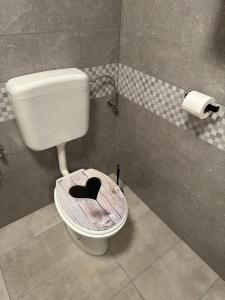 un bagno con un water con un cuore sul sedile di Apartma Anže Samec a Dobravlje Altre 37 foto