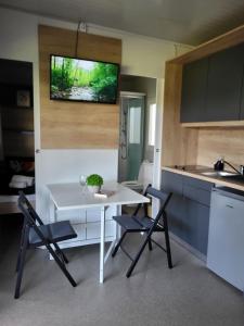 Il comprend une petite cuisine avec une table et des chaises blanches. dans l'établissement KOLPA - Luxury Natura House, à Gradac