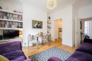 a living room with a purple couch and a table at 7 Mount Sion in Royal Tunbridge Wells