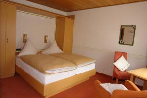 a bedroom with a bed with a window and a chair at Haus Hesseberg in Medebach