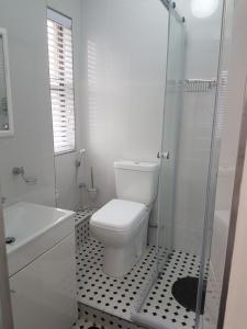a white bathroom with a toilet and a shower at 15 BRONZE BEACH UMHLANGA ROCKS DURBAN in Durban
