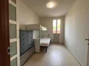 a bedroom with a bed and a dresser and a window at Azzurro Horizon Apartment in Bellaria-Igea Marina