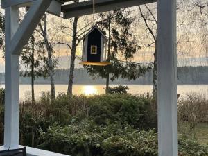 a bird feeder hanging from a porch with a view of a lake at Vogtis Ferienhaus am Glammsee in Warin