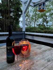 een fles wijn en twee glazen op een houten tafel bij Vogtis Ferienhaus am Glammsee in Warin