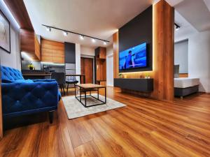 a living room with a blue couch and a tv at District Apartment in Bitola