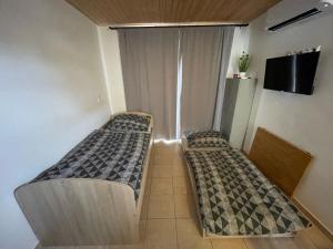two beds in a small room with a tv at Apartmán Stupava in Stupava