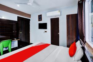 1 dormitorio con 1 cama y escritorio con silla verde en Collection O Mount Olympus Hotel, en Indirapuram