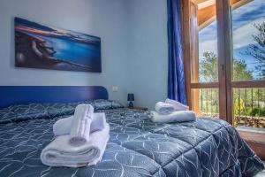 una camera da letto con asciugamani su un letto con finestra di Rovo house, Pittulongu, Olbia, Sardinia a Olbia