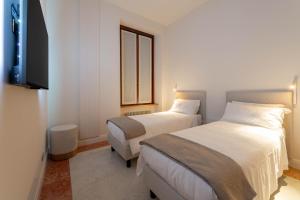 a hotel room with two beds and a flat screen tv at Palazzo Venier in Verona