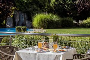 uma mesa com pratos de comida e bebidas em Klein Fein Hotel Anderlahn em Parcines