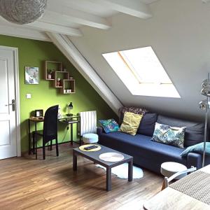 sala de estar con sofá azul y tragaluz en Joli gîte F2 indépendant avec jardin privé, en Rouffach