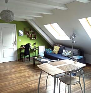 a living room with a couch and a table at Joli gîte F2 indépendant avec jardin privé in Rouffach +26 photos