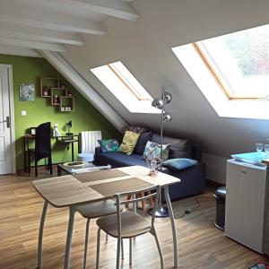 ロウファッハにあるJoli gîte F2 indépendant avec jardin privéのリビングルーム(テーブル、天窓付きのソファ付)