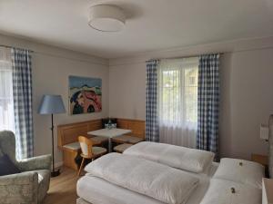 ein Wohnzimmer mit 2 Betten und einem Tisch in der Unterkunft Pension Alpenhof in Bad Aussee