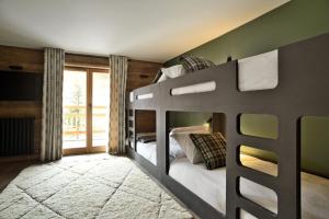 a bedroom with two bunk beds and a window at Chalet Fabriel in Montgenèvre