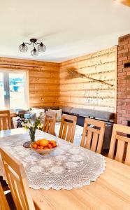 a dining room with a table with a bowl of oranges on it at Chata nad Roztokami in Mchawa