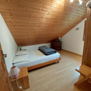 Cama en habitación con techo de madera en Gite De La Mortagne en Mortagne