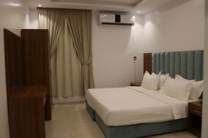 Habitación de hotel con cama y escritorio en طيف المكان للشقق الفندقية, en Riad