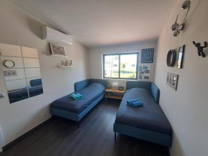 a living room with two blue couches and a window at Villa Ocean Waves in Aroeira