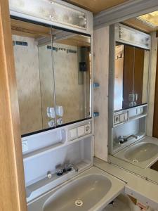 a bathroom with two sinks and two mirrors at AMOMEA CAMP in Jastarnia
