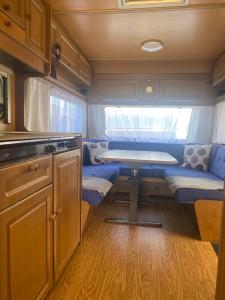 an interior of an rv with a kitchen and a table at AMOMEA CAMP in Jastarnia
