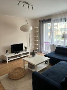 salon z niebieską kanapą i stołem w obiekcie Gdynia Apartament Torpedownia w mieście Gdynia