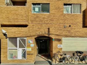 大阪市にある8人可能/部屋2つ/難波駅/大黒町駅 h503のレンガ造りの建物の前に駐輪した自転車2台