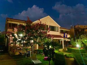 un edificio con un árbol delante de él en Vila M Vera Rooms with kitchen and Apartments, en Durrës