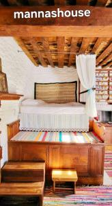 uma cama de madeira num quarto com uma casa de manaus em Mannashouse em Émbonas