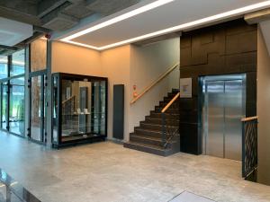 a lobby with a staircase and a glass elevator at Apartament w Bursztynowe Apartamenty Stegna in Stegna