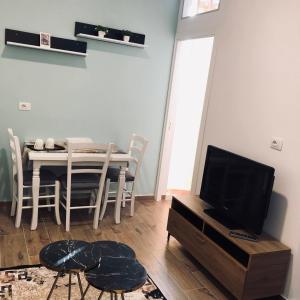 sala de estar con mesa y TV en Rezidenca SHOPI, en Elbasan