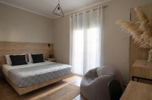 1 dormitorio con 1 cama y 1 silla en StayInn Luxury Apartments en Nea Kallikratia