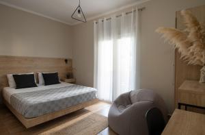 a bedroom with a bed and a chair at StayInn Luxury Apartments in Nea Kalikratia +189 photos