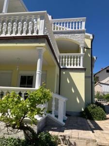 a house with a white railing and a balcony at Villa Georgina in Vodice