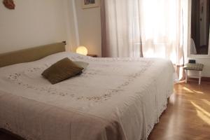 a bedroom with a white bed with a pillow on it at VECCHIA STAZIONE in Menaggio