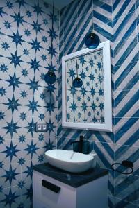 y baño con lavabo y paredes de azulejos azules y blancos. en Casa Rístori Calicanto, en Manzanares