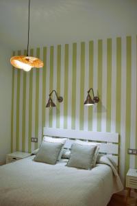 1 dormitorio con 1 cama con rayas verdes y blancas en Casa Rístori Calicanto, en Manzanares