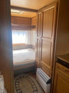 ein kleines Zimmer mit einem kleinen Bett in einer Küche in der Unterkunft AMOMEA CAMP in Jastarnia
