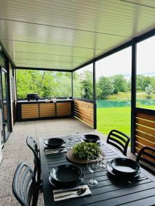 - une table et des chaises sur une terrasse couverte avec une table et des chaises dans l'établissement KOLPA - Luxury Natura House, à Gradac
