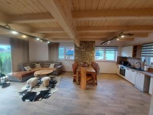 a large living room with a table and a kitchen at Domek u Andrzeja 3 in Ciche