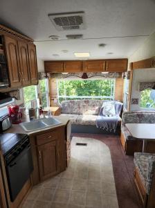 a kitchen and living room of an rv at Camping Beaurivage 2-Pret à camper pour 4 personnes in Routhierville