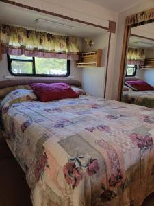 a bedroom with a large bed in a rv at Camping Beaurivage 2-Pret à camper pour 4 personnes in Routhierville