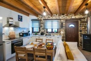 a kitchen with white cabinets and a table and chairs at Ntoukiani House in Epáno Khoríon