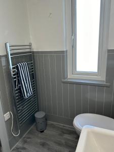 ein Bad mit einem weißen WC und einem Fenster in der Unterkunft Heavens Above in Warrenpoint