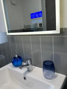 ein Waschbecken mit Spiegel und blauem Glas in der Unterkunft Heavens Above in Warrenpoint