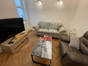 a living room with a couch and a tv at Luxury Apartment in Surbiton, good access to London Waterloo in Surbiton