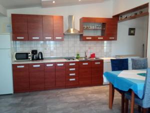 a kitchen with wooden cabinets and a blue table in it at KATY&MLADEN in Baška