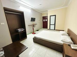 a bedroom with a bed and a desk and a television at Đình Vũ 3 Motel in Hai Phong